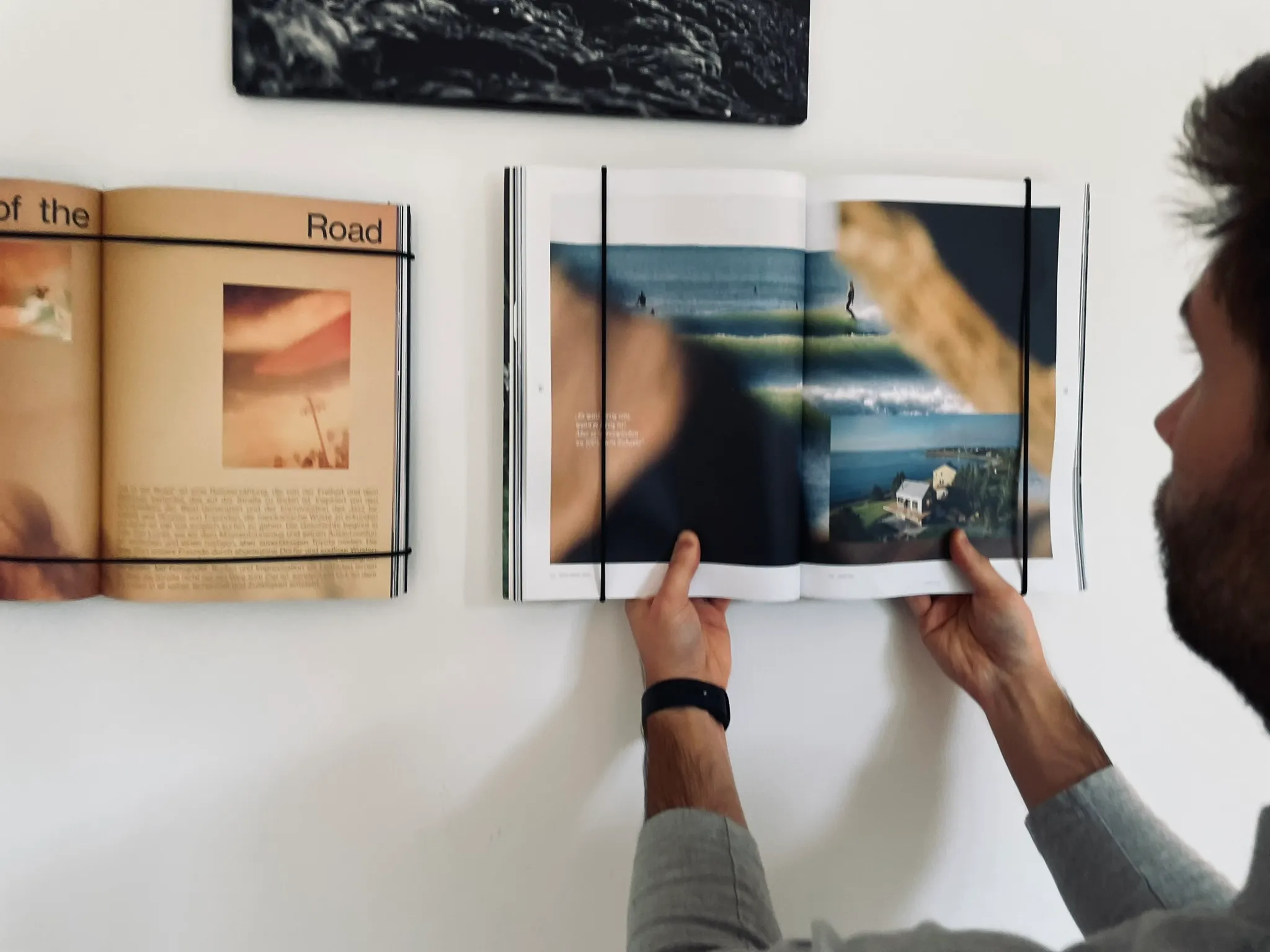Coffee Table Books im FOCUS | FRAME an der Wand, zwei Hände blättern um