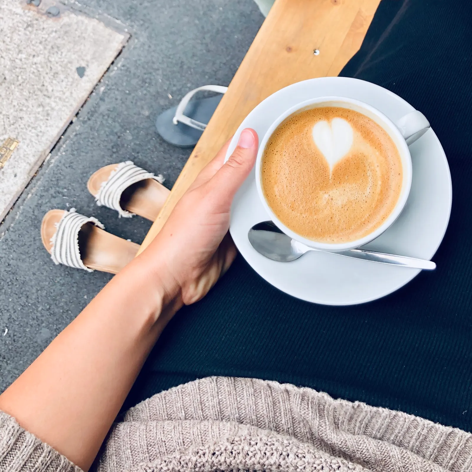 Cappuccino mit Latte Art in der Hand